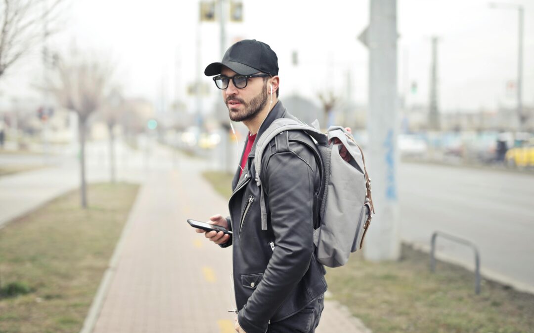 Man Wearing Black Leather Jacket Holding Smartphone